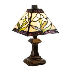 a table lamp with a stained glass shade on it's base and an ornate design