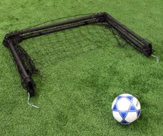 a soccer ball sitting on top of a field next to a goalie's net