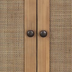 an old fashioned wooden door with two black knobs