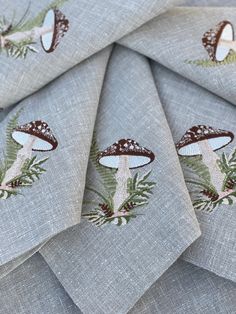 several napkins with mushrooms and ferns on them