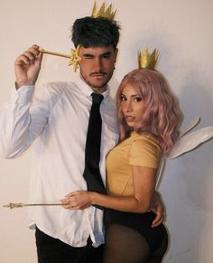 a man and woman dressed up as fairy tale characters, one holding a wand while the other holds an arrow