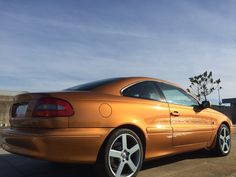 an orange sports car parked on the street