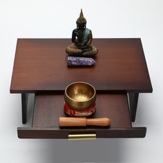 a buddha statue sitting on top of a wooden table