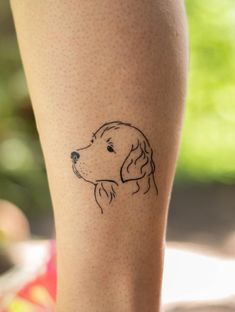 a dog's head is shown on the leg of a person with a small tattoo