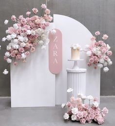 pink and white flowers are on display in front of a sign that says zara