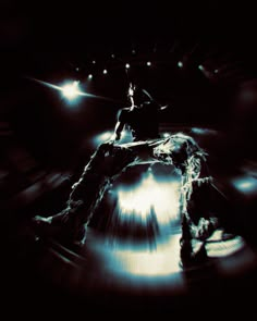 a man sitting on top of a rock in the middle of a dark room with lights