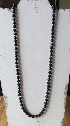 "8mm silky smooth matte finished onyx beads separated by smaller black beads and strung on the highest quality stainless steel beading wire for maximum strength and flexibility. Sizes available range from a short choker length to a long navel-grazing length. Anything 26\" and over is constructed to be an endless loop with no clasp to fumble with. Anything shorter than 26\" comes with a stainless steel tarnish resistant lobster clasp. Materials used are: 8mm matte black onyx 2mm black beads Stain Beaded Necklace For Men, Pearl Necklace Men, Black Gemstone Necklace, Holly Springs Nc, Mens Beaded Necklaces, Black Pearl Necklace, Black Onyx Necklace, Gem Necklace, Onyx Necklace