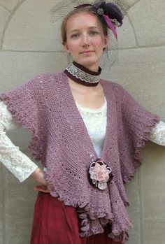 a woman wearing a purple knitted shawl with flowers on it and a veil over her head