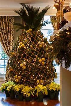 a pineapple christmas tree is decorated with lights and greenery for the holiday season