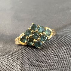 This vintage ring features 9 green labradorite stones in a diamond shaped cluster, all beautifully set in 14k yellow gold. Each stone is 3mm diameter and they are set in shared prongs. The detailed band has a faux split design and the base of the shank is 2.1mm wide. Size 9 Weight is 3.39g Green Gem, Split Design, Green Gems, Labradorite Ring, Labradorite Stone, Vintage Yellow, Diamond Shapes, Vintage Rings, Labradorite