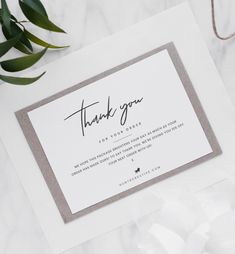 a thank card with the words, thank you on it next to some white flowers