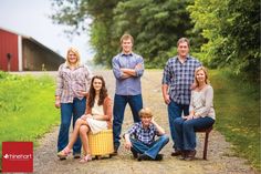 a family posing for a photo in front of a barn