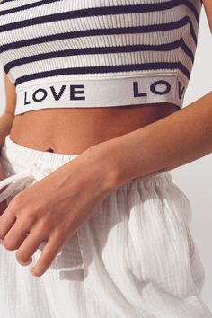 Introducing our stylish Striped Crop Top with Love Text in White, a trendy and comfortable addition to your wardrobe. Designed with attention to detail, this crop top offers a perfect blend of style and comfort. With its cropped length, this top is perfect for creating a fashionable and contemporary look. The stripe design adds a touch of sophistication, while the contrast collar adds a stylish element to the overall design. The sleeveless style allows for ease of movement and breathability.  Th White Cropped Hem Crop Top For Summer, White Cropped Hem Crop Top For Spring, White Cotton Crop Top With Cropped Hem, Chic Cropped Hem Crop Top For Summer, Chic Slightly Cropped Cotton Crop Top, Chic Beach Tops With Elastic Waistband, Spring Cotton Crop Top With Elastic Waistband, White Crop Top For Loungewear In Spring, Chic Fitted Crop Top With Elastic Waistband