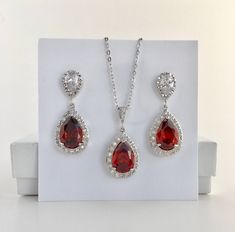 I've created this luxury red ruby cubic zirconia bridal tear drop earrings in rhodium plated brass setting. Earrings feature a large teardrop with pear cut red ruby cubic zirconia center surrounded by tiny round zirconia crystals. Teardrop dangles from a bright cubic zirconia ear stud. Total length of the earring is 3.5 cms. For matching necklace click: https://www.etsy.com/listing/469844682/red-ruby-cubic-zirconia-teardrop-bridal?ref=shop_home_active_26 For matching bracelet: https://www.etsy.c Ruby Teardrop Pendant Jewelry For Wedding, Wedding Ruby Teardrop Pendant Jewelry, Ruby Teardrop Pendant For Wedding, Red Pear-shaped Wedding Earrings, Red Cubic Zirconia Pear-shaped Jewelry, Red Pear-shaped Cubic Zirconia Jewelry, Red Pear-shaped Cubic Zirconia Earrings, Formal Red Cubic Zirconia Bridal Earrings, Ruby Red Wedding