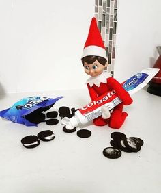 an elf is sitting next to some oreos and toothpaste