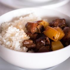 a white bowl filled with rice and meat