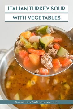 a ladle full of italian turkey soup with vegetables and meat in it, on top of a white table