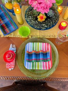 the table is set with colorful dishes and place settings