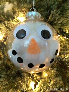 a snowman ornament hanging from a christmas tree with the words, how to make