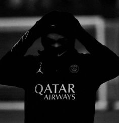 black and white photo of a man wearing a hoodie with the word qatar airways on it