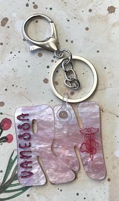 a key chain with the word love is hanging from it's center and two letters on