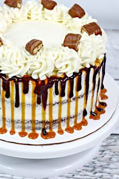 a cake with white frosting and caramel drizzles on the top