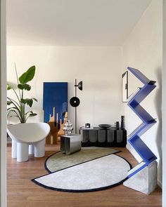 a living room filled with furniture and art on the wall next to a wooden floor