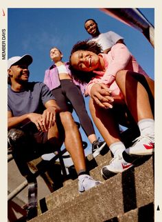 a group of people sitting on steps with one woman holding the other's head