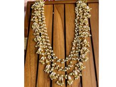 Elevate your look with this stunning 3-layer Rani Haar style pearl necklace, featuring delicate rice pearls, small gold stones, and beads. Perfect for adding elegance to any occasion, this very long pearl necklace is a timeless Indian jewelry piece. Ideal for those seeking a classic long pearl strand. Necklace Only Necklace Has Been Adjustable Cord Gold Tone , Pearl , Stone , Beads Gold Pearl Chain Necklace Choker Women Pearl *SHOP LINK - https://www.etsy.com/shop/ColourstoneWorld?ref=profile_he Wedding Multi-strand Pearl Drop Necklace, Wedding Multi-strand Pearl Necklace With Pearl Drop, Wedding Pearl Necklace With Multi-strand Pearl Chain, Gold Pearl Necklace For Reception, White Pearl Chain Necklace For Receptions, Gold Pearl Drop Necklace For Reception, Gold Bridal Necklace With Round Beads For Reception, Gold Pearl Chain Necklace For Reception, Gold Pearl Necklace With Pearl Chain For Reception