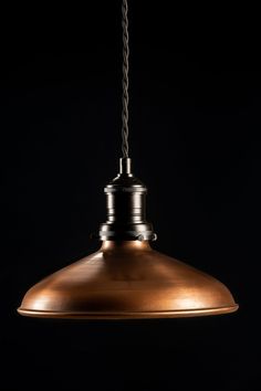 an industrial style pendant light hanging from a ceiling fixture with a rope attached to it