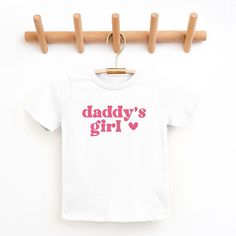 Looking for a cute tee for your kids? We have the perfect Daddy's Girl Heart graphic tee addition to their closet! Also available in youth tees. Playful Pink T-shirt With Slogan, Cute White T-shirt With Letter Print, Cute Cotton T-shirt With Heart Graphic, Playful White T-shirt With Heart Graphic, White Playful T-shirt With Heart Graphic, Playful Cotton T-shirt With Heart Graphic, Cute White T-shirt With Heart Graphic, Cute Mother's Day Graphic Print T-shirt, Cute Graphic Print T-shirt For Mother's Day