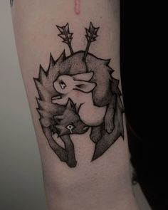 a black and white photo of a tattoo design on the right arm, with an image of two foxes