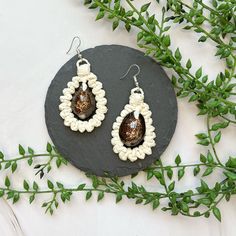 All Speck products were made by REAL Pacific Island women with REAL native Pacific Island materials. ITEM DESCRIPTION: These bold teardrop earrings feature fine strands of naiu (young coconut leaf) with a jumbo dark money cowrie shell centerpiece. Earrings measure 1.5" tall and 1.25" wide. ABOUT SPECK: Speck was created to help Pacific Island natives share the genuine beauty and culture of their islands. All Speck products were designed and created by Pacific Island natives. Every necklace, brac Island Women, Shell Centerpieces, Coconut Leaves, Island Jewelry, Mailing Envelopes, Cowrie Shell, Real Women, Necklace Bracelet, Teardrop Earrings