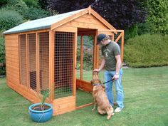 a man standing next to a dog in front of a chicken coop