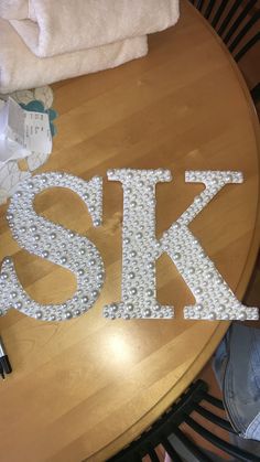 the letters are made out of pearls on top of a table