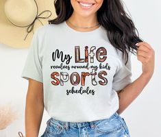 a woman wearing a t - shirt that says, my life reminds my kids sports schedules