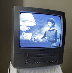 an old television sitting on top of a bed