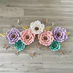 some paper flowers and butterflies on a wooden floor