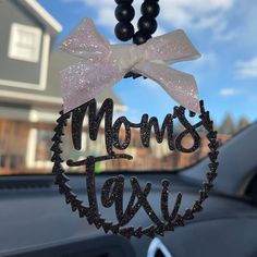 a mom's day ornament hanging from the front window of a car