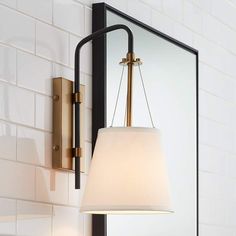 a lamp hanging from the side of a wall next to a mirror and light fixture