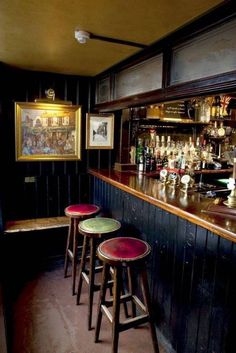 three stools sitting in front of a bar