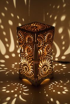 an intricately designed lamp is shown in the shadows