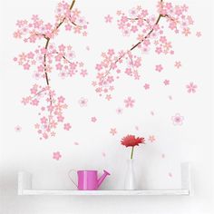 pink flowers are in vases on a shelf next to a wall with white walls