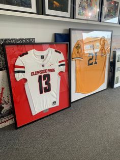 Turn your jersey in to framed wall art for your home. Black wooden jersey frame with acrylic plexiglass front for protect your jersey framing. Each framed jersey is ready to hang on your wall once’s delivered. We frame all jersey : football, soccers, baseball, wrestling, softball and we even custom frame tshirt jerseys T Shirt Frame Display, Framed Football Jersey, Framed Jersey Ideas, Frame Jersey Ideas, Tshirt Wall Art, Picture Frame Store, Jersey Frame, Box Sport, T Shirt Frame