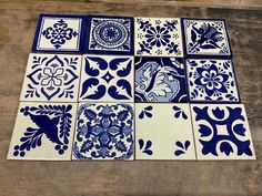 blue and white tiles laid out on a wooden floor with different designs in the middle