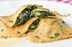 some ravioli with spinach and cheese on a white plate