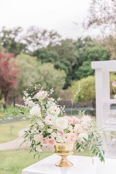 a vase filled with flowers sitting on top of a white table next to a chair