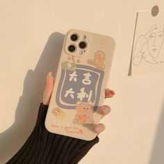 a woman's hand holding a phone case with chinese characters on it