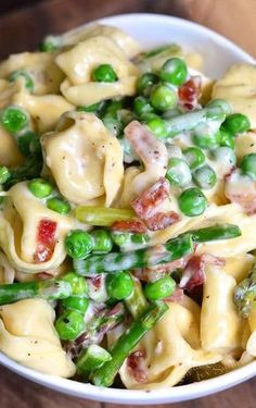 a white bowl filled with pasta and peas