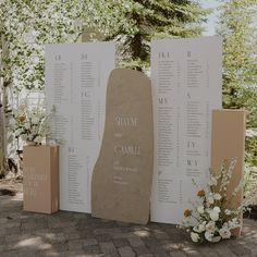 an outdoor ceremony setup with seating cards and flowers on the ground next to each other